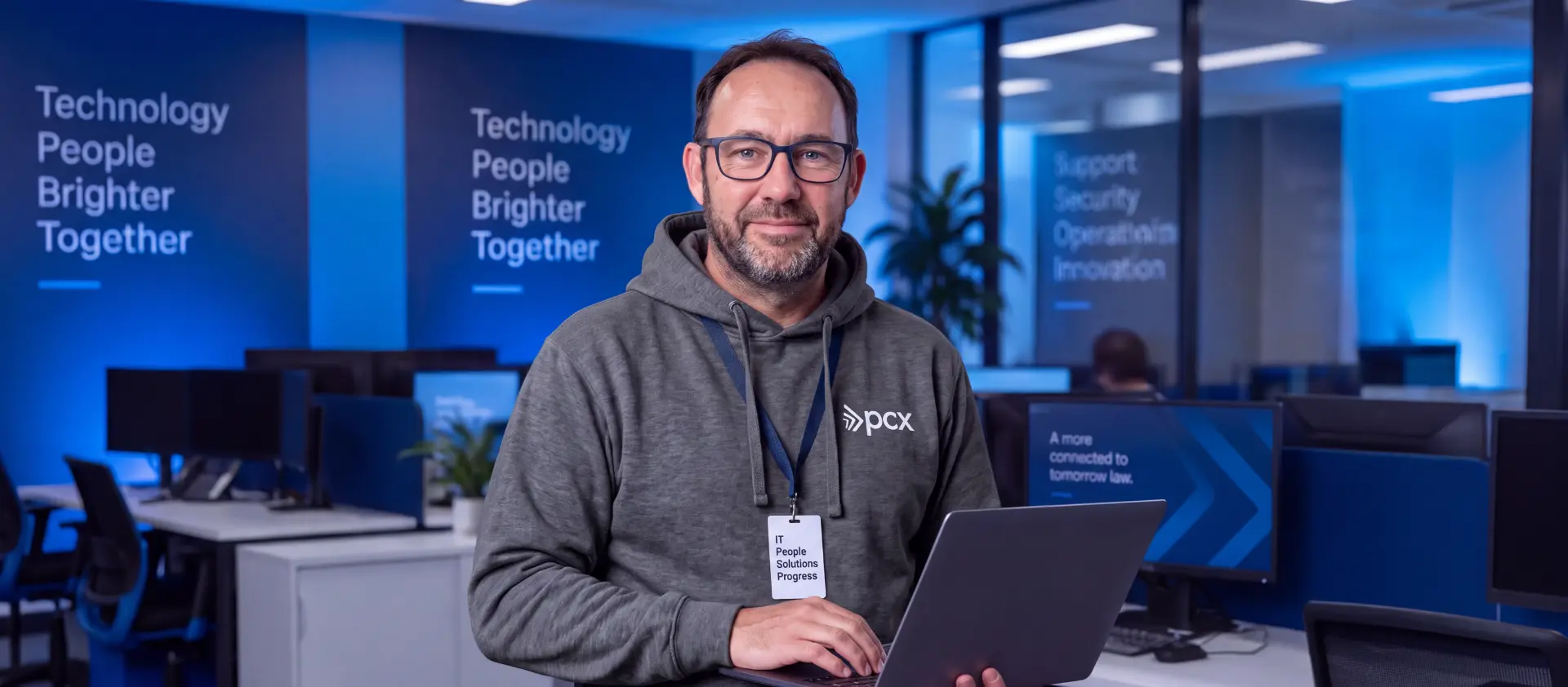 PCX IT engineer holding a laptop, ready to help